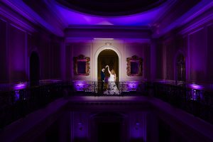 Couple lit by camera flash dance in the archway on the mezzanine at Hedsor House