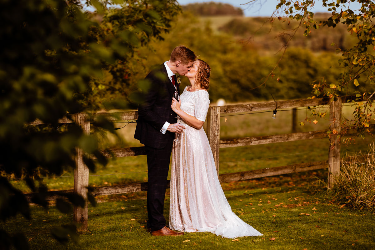 Kissing bride & groom in the garden of Combe Manor